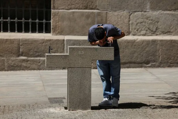 A person drinks from a fountain rest during a spring heatwave in Madrid, Spain, May 27, 2026. (Reuters)