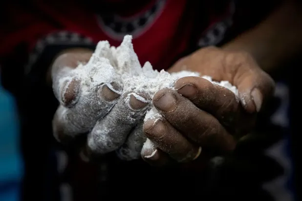 Yemen’deki bir mülteci kampında bulunan bir kadın, ailesi için yemek hazırlamak üzere elinde bir avuç un tutuyor. (AP)