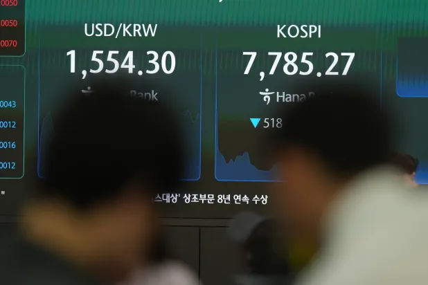 شاشات تعرض مؤشر «كوسبي» وسعر صرف العملات الأجنبية بين الدولار الأميركي والوون الكوري الجنوبي في غرفة تداول تابعة لبنك هانا بسيول (أ.ب)