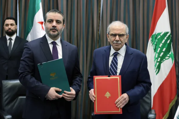 رئيس الحكومة اللبنانية نواف سلام ووزير الخارجية السوري أسعد الشيباني يعرضان اتفاقية إنشاء «اللجنة العليا» بعد توقيعها (إ.ب.أ)