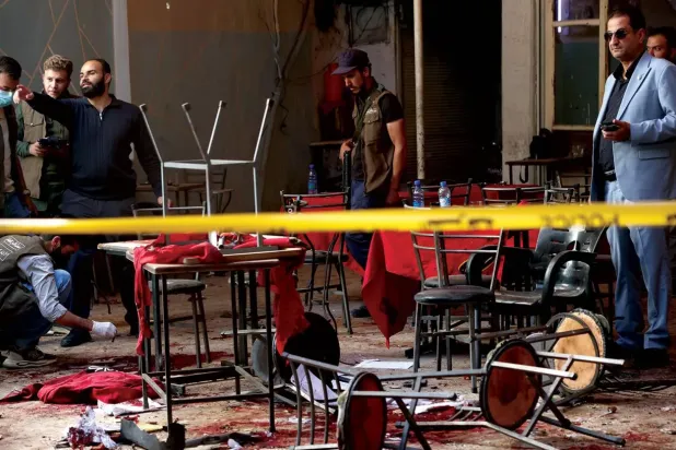 Suriye güvenlik güçleri dün Şam'daki adliye kompleksi yakınlarındaki bir kafede meydana gelen bombalı saldırının olay yerini inceliyor (AP)