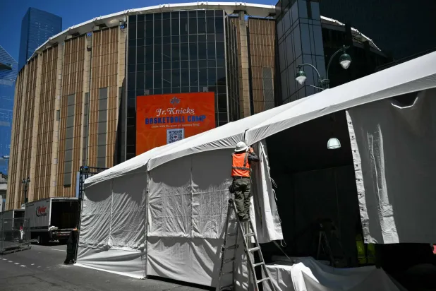 A worker makes adjustments to a tent outside Madison Square Garden, the reported venue for the wedding celebrations of pop singer Taylor Swift and pro-athlete Travis Kelce, in New York City on July 3, 2026. (AFP)