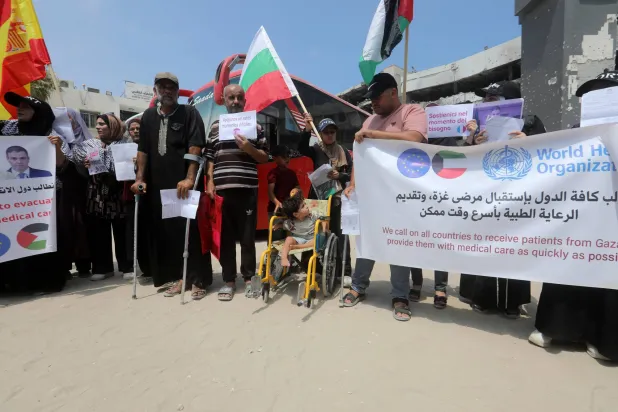 فلسطينيون جرحى وذووهم في وقفة احتجاجية يوم الأحد أمام مستشفى الشفاء في مدينة غزة يطالبون بالسماح للمرضى والجرحى بالسفر للعلاج (د.ب.أ)