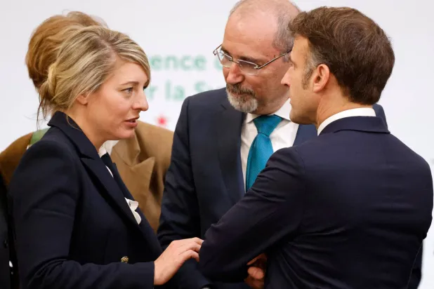وزيرة الخارجية الكندية ميلاني جولي تتحدث مع الرئيس الفرنسي إيمانويل ماكرون في مؤتمر سوريا بباريس بحضور وزير الخارجية الأردني (رويترز)