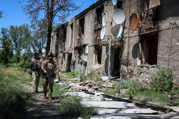 Servicemen of the consolidated Brigade "Khyzhak" of the Ukrainian Patrol Police Department walk near a destroyed apartment building as they take part in a mission to protect a road from Russian drones between frontline towns of Druzhkivka and Kostiantynivka, amid Russia's attack on Ukraine, in Donetsk region, Ukraine June 24, 2026. (Reuters)