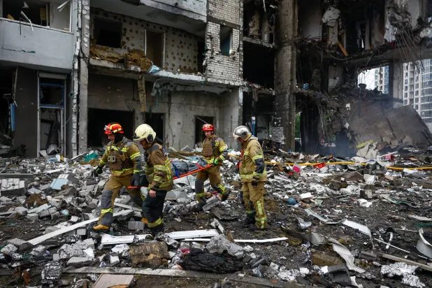 Rescuers carry the body of a resident found under debris inside an apartment building, which was hit during Russian missile and drone strikes, amid Russia's attack on Ukraine, in Kyiv, Ukraine, July 6, 2026. REUTERS/Valentyn Ogirenko