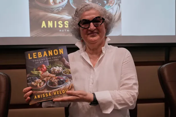 Anissa Helou, 74, one of the Middle East's most acclaimed cooks and food writers, holds her new book during a ceremony at the Lebanese Ministry of Tourism, in Beirut, Lebanon, Tuesday, June 23, 2026. (AP Photo/Hussein Malla)
