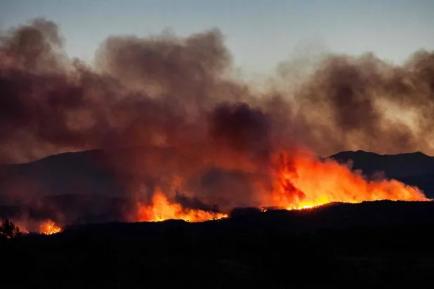 This photograph shows a wildfire burning in the Aspres region seen from Millas, in the Pyrenees-Orientales department, southern France on July 5, 2026. (AFP) 