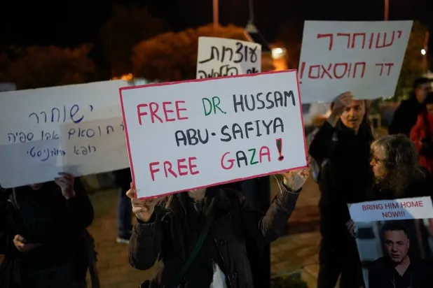 A woman holds a sign that reads "Free Dr. Hussam Abu Safiya, Free Gaza" during a protest in front of the Shin Bet offices, calling for his release, in Tel Aviv, Israel, on Jan. 1, 2025. (AP)