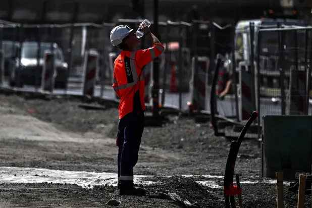 A worker drinks water from a plastic bottle at a construction site in Bordeaux, southwestern France on June 22, 2026, as France experiences a ferocious heatwave. (AFP)