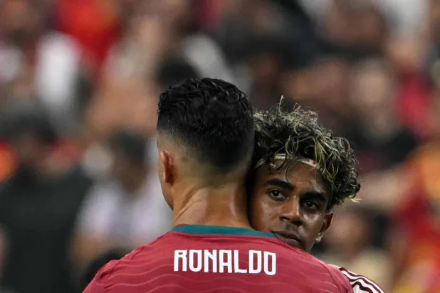 كريستيانو رونالدو ولامين يامال يعانقان بعضهما بعد مباراة دور الـ16 لكأس العالم 2026 بين البرتغال وإسبانيا (أ.ف.ب)