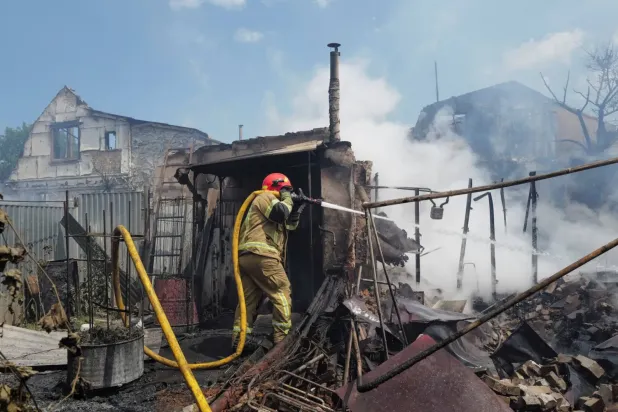 Pazartesi günü Kiev'in banliyölerinde Rus hava saldırılarının ardından çıkan yangını söndürmeye çalışan bir itfaiyeci (Reuters)