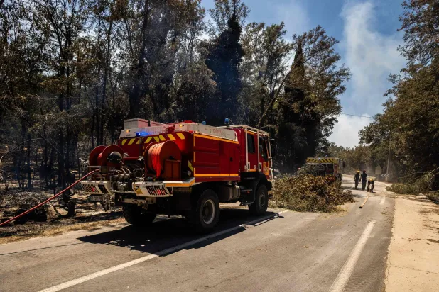 Firefighters work on a burnt area as a wildfire rages in the southern France department of Pyrenees-Orientales in the town of Ille-sur-Tet, near Perpignan on July 6, 2026. (AFP)