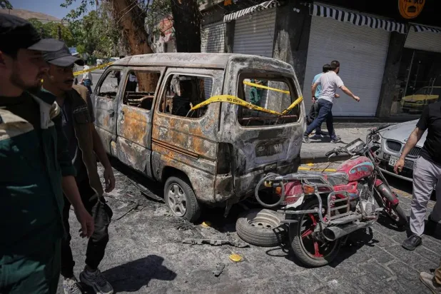 Syrian security personnel inspect a burned vehicles near the Four Seasons Hotel after two explosions rocked the area earlier while Syrian President Ahmed al-Sharaa was meeting French President Emmanuel Macron at the presidential palace, in Damascus, Syria, Tuesday, July 7, 2026. (AP) 