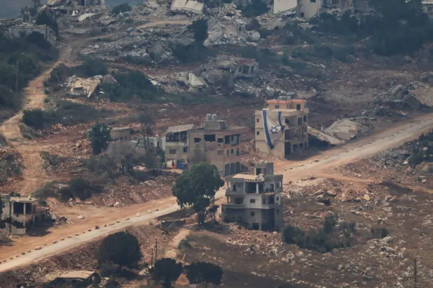  An Israeli flag hangs from a building in Lebanon as seen from the Israeli side of the Israel-Lebanon border, in northern Israel, July 5, 2026. (Reuters)