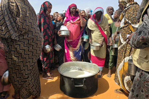 Sudanese women gather for a hot meal in al-Rahmaniyah camp for displaced people, near the city of el-Obeid in the southern Kordofan region on July 7, 2026. (AFP)