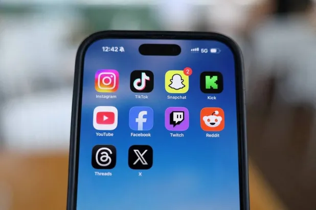 Instagram, TikTok, Snapchat, Kick, YouTube, Facebook, Twitch, Reddit, Threads and X applications are displayed on a mobile phone in this picture illustration taken on December 9, 2025. (Reuters)