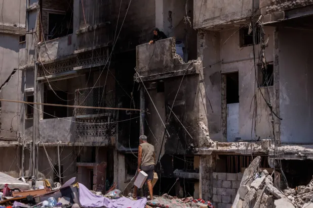لبناني ينقل مواد بناء خلال ترميم منزله الذي تضرر جراء غارة إسرائيلية استهدفت مدينة صور في جنوب لبنان (رويترز)