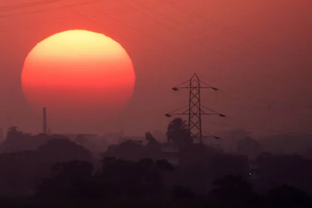 The sun behind high-voltage power lines and electricity pylons along the River Nile during a heatwave in Al-Qanatir al-Khairia, on the outskirts of Cairo, Egypt, July 4, 2026. REUTERS/Amr Abdallah Dalsh