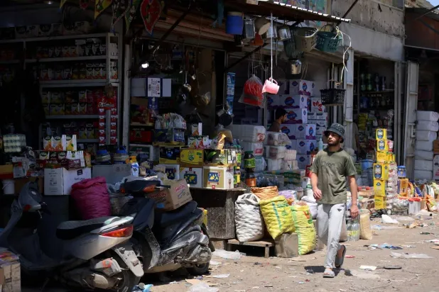  An Iraqi man walks past shops in the Jamila food market in Sadr City, east Baghdad on April 13, 2026. (AFP) 