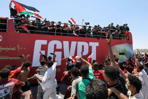 لاعبو منتخب مصر يحيون الجماهير من حافلة مكشوفة (رويترز)
