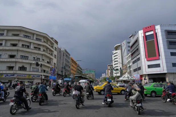 FILE - Motorbikes and cars pass through an intersection in downtown Tehran, Iran, May 17, 2026. (AP Photo/Vahid Salemi, File)