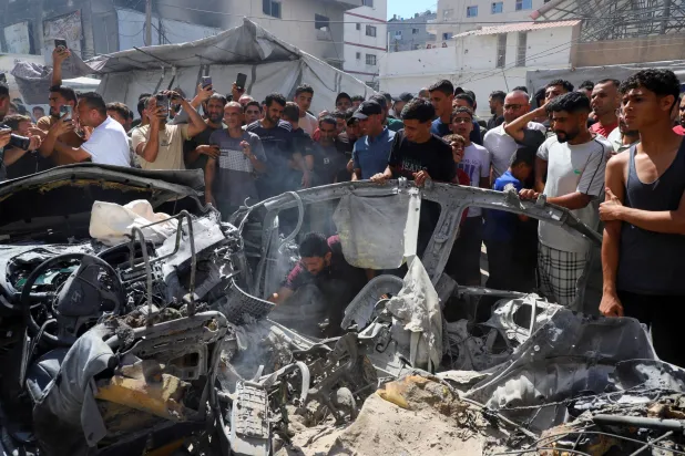 Palestinians inspect the site of an Israeli strike on a vehicle in Gaza City, July 9, 2026. (Reuters)