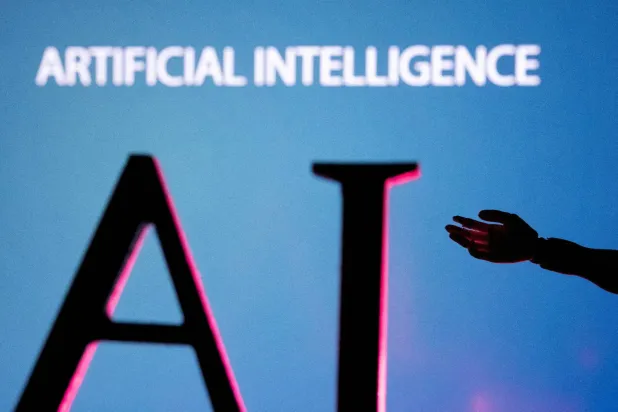 AI (Artificial Intelligence) letters and robot hand miniature in this illustration taken, June 23, 2023. (Reuters)