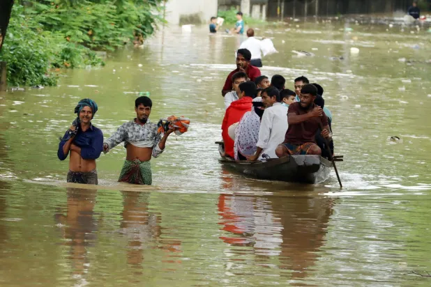 11 July 2026, Bangladesh, Dhaka: People wade through floodwaters in Dhaka, after torrential rain caused severe flooding and waterlogging across parts of the country. (dpa) 