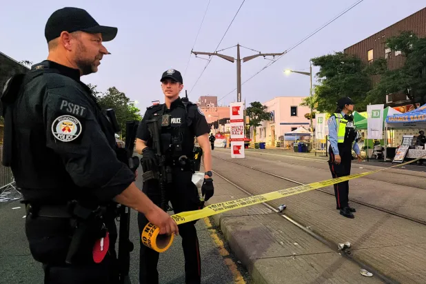 Police officers secure the scene after a deadly shooting at a salsa-themed street festival in Toronto, Ontario, Canada, July 11, 2026. Picture taken using a mobile phone.  REUTERS/Cole Burston