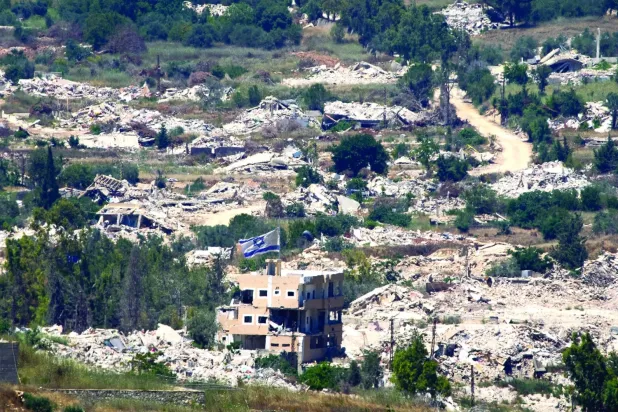 Lübnan'ın güneyinde hasar görmüş bir binaya asılı İsrail bayrağı (AP)