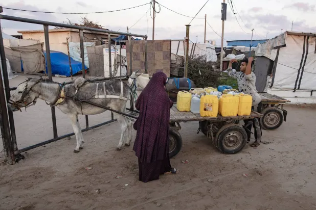 Displaced Palestinians collect water from the Ita charitable water station, amid ongoing water shortages and limited access to water sources, in Khan Younis, Gaza Strip, 13 July 2026. EPA/HAITHAM IMAD