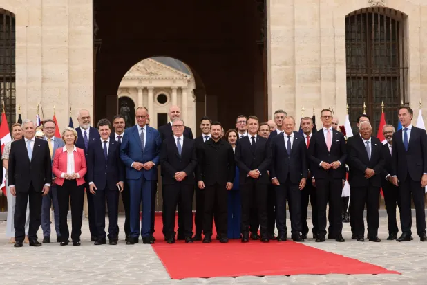 French President Emmanuel Macron (C-L) and Ukrainian President Volodymyr Zelensky (C) pose for a group photo with heads of states and governments ahead of the Coalition of the Willing summit on security guarantees for Ukraine at the Hotel des Invalides in Paris, France, 13 July 2026. (EPA)