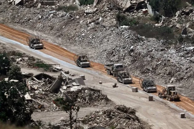  An Israeli military vehicle covered with netting to protect against FPV drones patrols on the Lebanese side of the border, as seen from an undisclosed location along the border, 13 July 2026. (EPA)