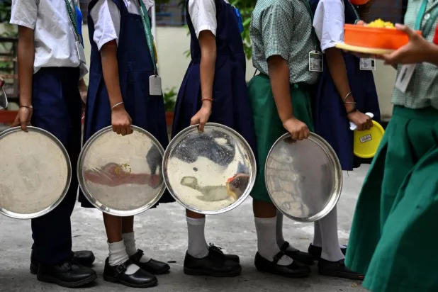 Students queue to receive lunch at a government-run primary school in Kolkata, India. Dibyangshu SARKAR / AFP
