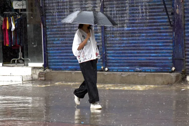 A woman walks along a road amid heavy monsoon rain in Lahore, Pakistan, 12 July 2026. EPA/A. HUSSAIN
