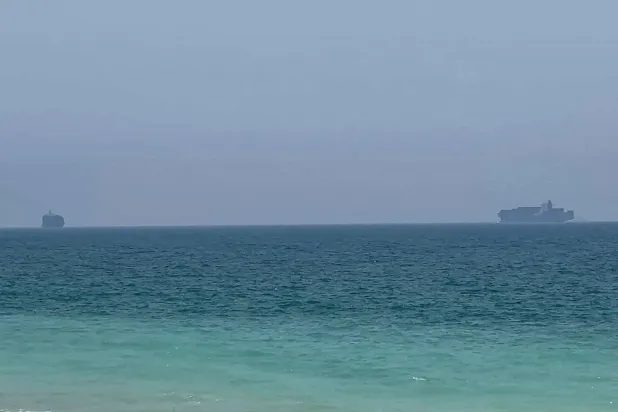 This frame grab taken from AFPTV video footage on July 12, 2026 shows cargo ships anchoring near the Strait of Hormuz off the eastern coast of the United Arab Emirates at Khor Fakkan.(AFPTV/AFP)