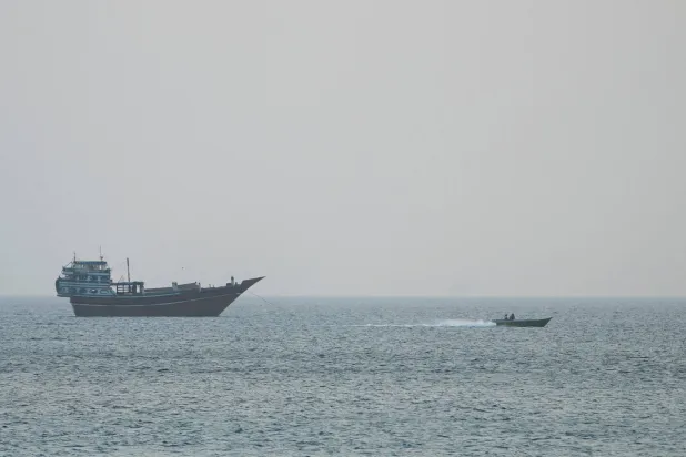 سفينة في مضيق هرمز كما تُرى من مسندم في عُمان (رويترز)