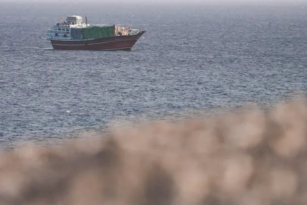 سفينة في مضيق هرمز كما تُرى من مسندم عُمان (رويترز)