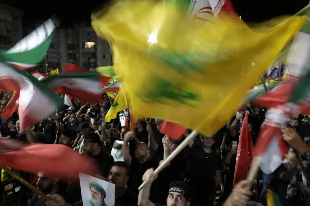 أنصار لـ«حزب الله» يلوحون بأعلام إيرانية خلال مراسم تأبين المرشد علي خامنئي في الضاحية الجنوبية لبيروت (إ.ب.أ)