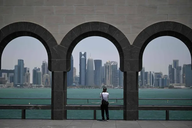 A visitor to the Museum of Islamic Art takes pictures of the skyline of highrise buildings in Doha on July 9, 2026. (AFP)