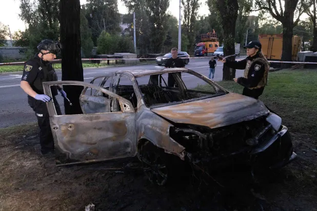 17 July 2026, Ukraine, Kharkiv: Ukrainian police officers examine a charred vehicle following a russian 'banderol' missile strike on a road in Kharkiv's Shevchenkivskyi district. Photo: Yevhen Titov/ZUMA Press Wire/dpa