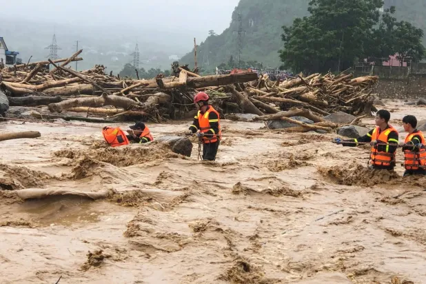 Kurtarma ekipleri, Vietnam'ın kuzeyindeki Muong Thanh bölgesinde sel gibi akan çamurun ortasında çalışıyor (AFP)