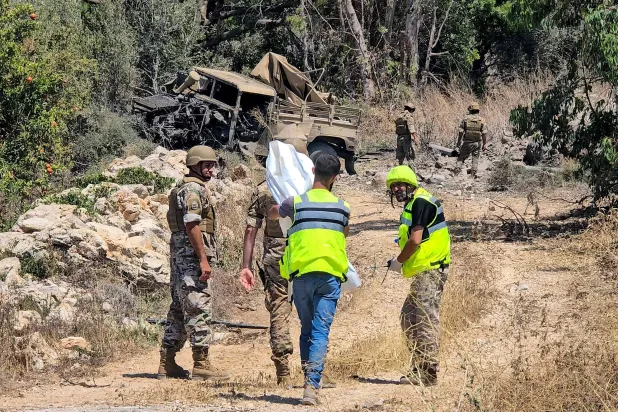 جنود من الجيش اللبناني يتفقدون موقع انفجار في منطقة المنصوري بجنوب لبنان حيث قتل عسكري وجرح اثنان آخران (أ.ف.ب)