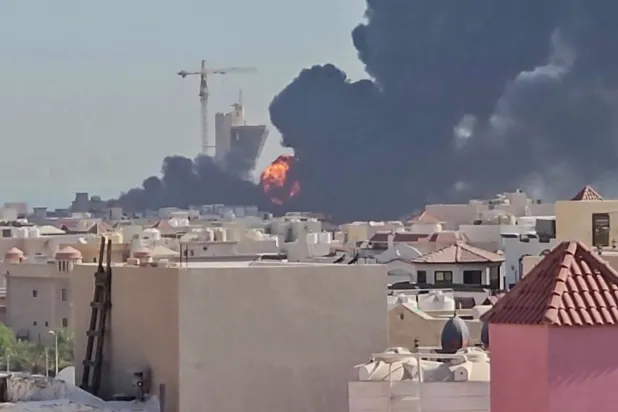 This screen grab taken from UGC video footage posted on social media on July 18, 2026, shows a plume of black smoke and flames billowing over the town of Mangaf, south of Kuwait City. (Photo by various sources / AFP) 