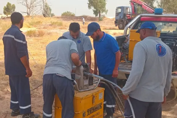 فنيو الشركة العامة للكهرباء في ليبيا خلال عملية صيانة على أحد الخطوط بطرابلس يوم الأحد (الشركة)