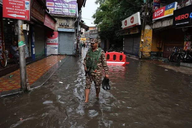 An Indian paramilitary soldier crosses a waterlogged street after heavy rainfall in Srinagar, India, 20 July 2026. (EPA) 