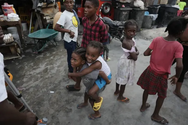 Haiti'nin başkenti Port-au-Prince’da çete şiddeti nedeniyle yerinden edilmiş aileler için kurulan bir sığınma merkezinde oynayan çocuklar, 19 Kasım 2025 (AP)