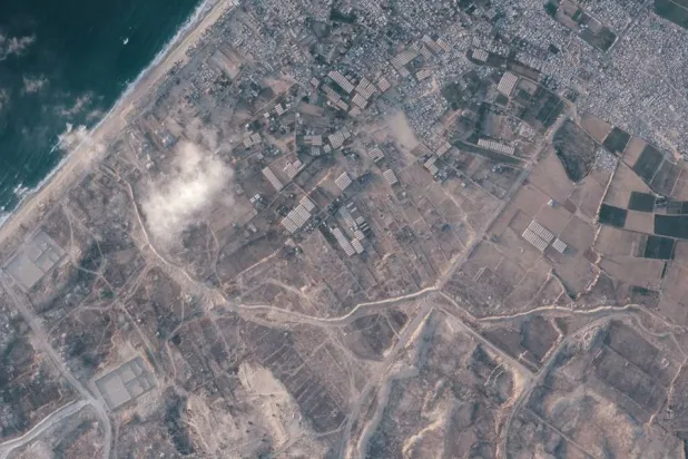 A satellite image from Planet Labs PBC shows a section of an earthen barrier, cutting horizontally across the middle of the image, being built by the Israeli military in the southern Gaza Strip, July 15, 2026. On one side are two military bases, and on the other the Palestinian tent city of Muwasi. (Planet Labs PBC via AP) 
