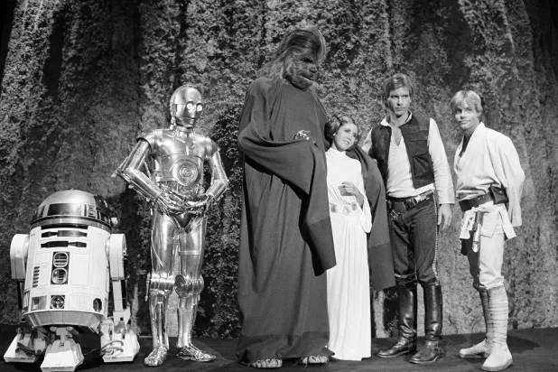 Kenny Baker, from left, Anthony Daniels, Peter Mayhew, Carrie Fisher, Harrison Ford and Mark Hamill are seen during the filming of the CBS-TV special, "The Star Wars Holiday," in Los Angeles, Nov. 13, 1978. (AP Photo/George Brich, File) 
